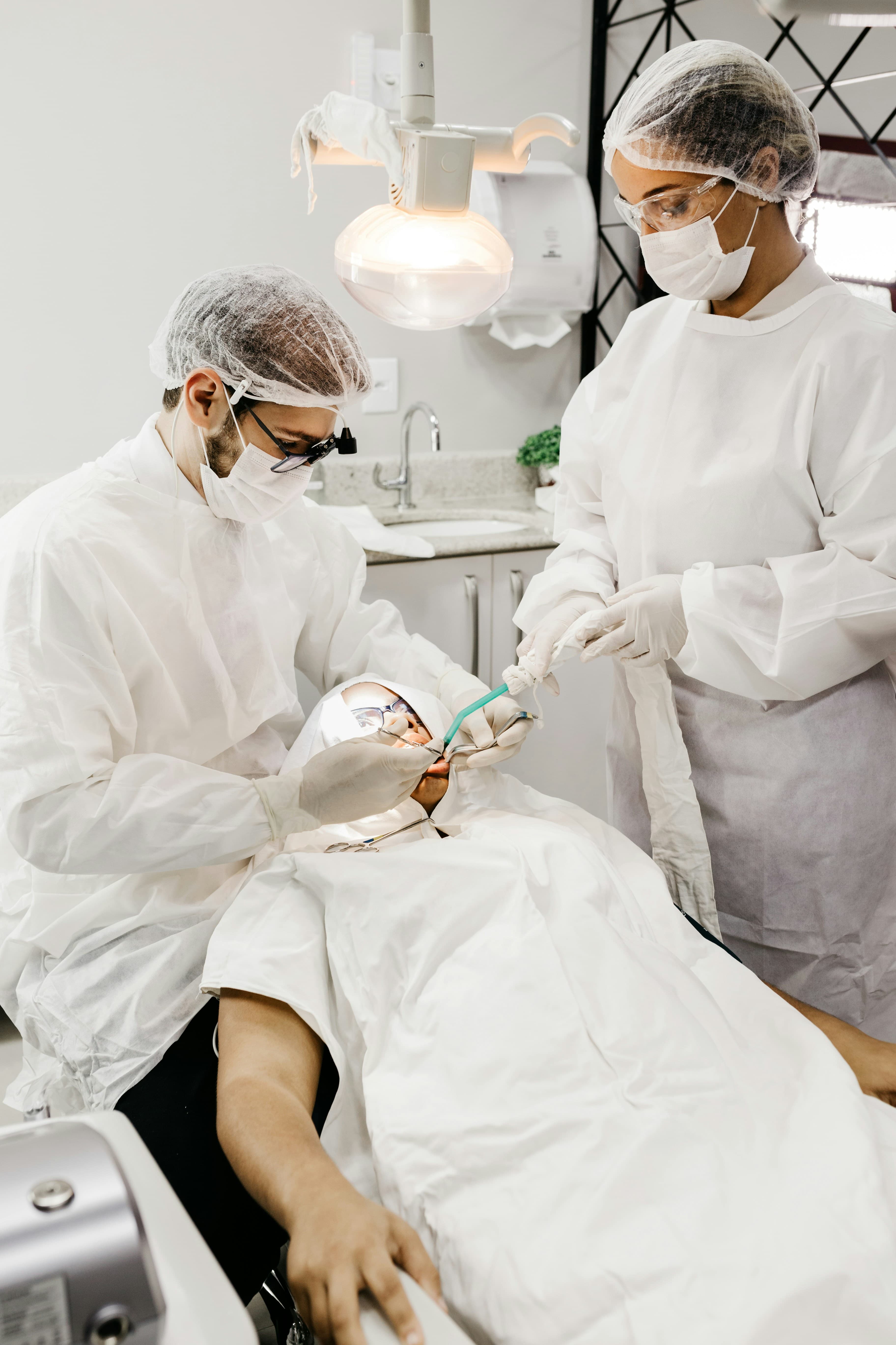 Hai bác sĩ nha khoa đang thực hiện thủ thuật cho bệnh nhân